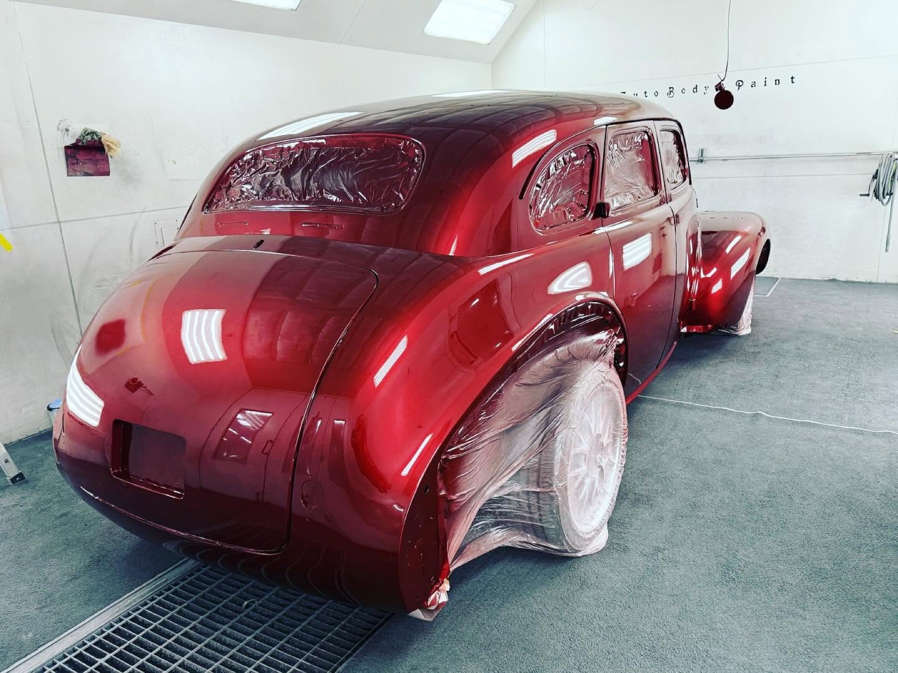 Freshly painted red classic car inside the Crazy Color paint booth